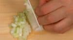 玉ねぎは垂直に包丁を入れ、最初の切り込みにクロスして切り、みじん切りにします。