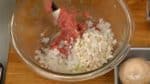 Agrega la cebolla picada y los tallos de shiitake a la mezcla y mezcla levemente.