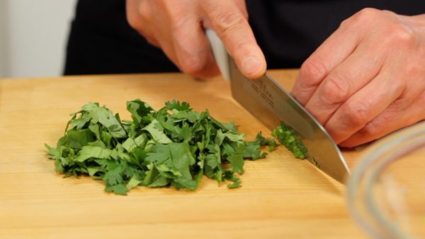 Let's make the salsa. Cut the coriander leaves into small pieces. Chop up the stems.