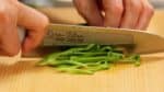 Cắt ớ chuông xanh làm đôi theo chiều dọc và loại bỏ lõi và hạt. Nhấn nó bằng tay bạn để làm phẳng ra và thái ớt thành các miếng vừa.