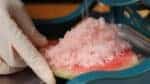 把西瓜冰沙刮到冷冻过的瓜皮上，偶尔调整一下形状，以便最后成形是西瓜的形状。