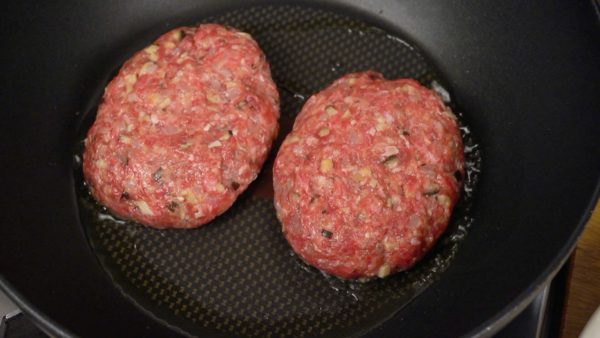 Chúng tôi sẽ nấu bít tết hamburg. Làm nóng dầu Ô-liu trong chảo. Để các miếng thịt vào chảo và nhấn nhẹ bằng tay bạn.
