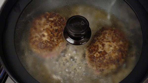 When both sides are completely browned, pour the water into the pan. Cover and fry the patties for about 8 minutes until the water almost evaporates.