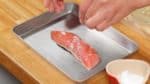 Salt both sides of the salmon fillet and lightly pat the surface with your fingers. Then, let the fillet sit for 15 minutes.