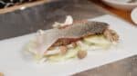Placez le saumon sur les champignons et saupoudrez généreusement de poivre.