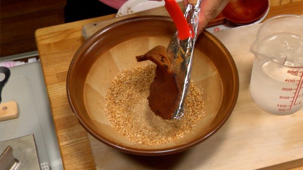 When they are half ground, add the toasted miso to the sesame seeds. Mix them with the surikogi pestle.
