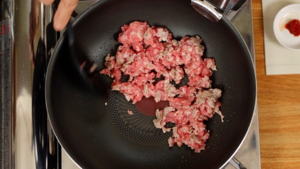 Let's make the meat mixture. Add the vegetable oil to a pan and turn on the burner. Distribute the oil. Then, place the ground beef and pork mixture into the heated pan. You can also use a single ground meat.