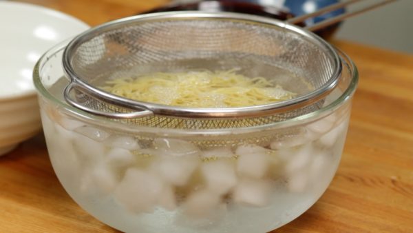 Using a mesh strainer, rinse the noodles with running water. Then, quickly place the noodles into a bowl of ice water.