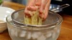 麺の表面のぬめりを取るように氷水でしっかりと洗います。のどごしがとても良くなるので必ず氷水で締めてください。麺をざるに取り、手でつかんでしっかり水気を絞ります。