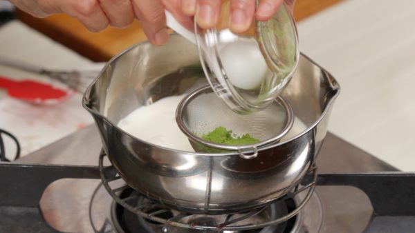 Let’s combine the cream mixture. Pour the milk into a pot. And add the heavy cream. Sieve the matcha green tea powder into the pot.