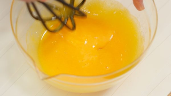 Next, break the 2 egg yolks and add the sugar. Beat the egg mixture thoroughly with a balloon whisk.