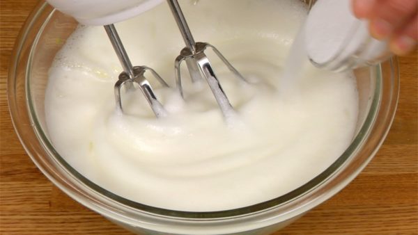 Prepariamo l'impasto del pan di Spagna. Sbattete in una ciotola quattro albumi d'uovo con le fruste elettriche. Quando si presentano schiumosi come nell'immagine, aggiungete metà dello zucchero. Sbattete ancora, e aggiungete il resto dello zucchero.