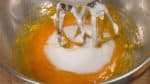 Retirez la meringue des batteurs. Ensuite, mélangez doucement les 4 jaunes d’œufs dans un bol. Ajoutez le sucre et continuez à mélanger. 