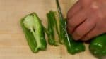 Coupez les poivrons en deux. Retirez les tiges et les graines. Coupez les poivrons en lamelles de 3mm (0.1 inch). Pincez le persil et hachez-le en petits morceaux.