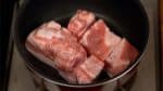 Mettre les cubes de porc dans un faitout anti adhésif chaud. Bien les faire frire à feu moyen. Vous n'avez pas besoin d'ajouter de l'huile, le gras va s'extraire de la poitrine de porc.