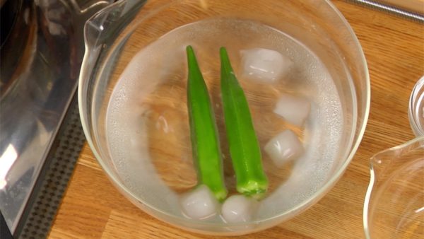 Remove and quickly cool the okra in a bowl of ice water to help retain its color. When cooled, remove the excess water with a paper towel. Chop it into thin slices.