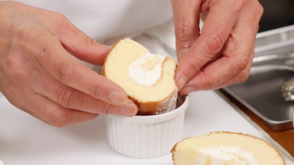 Pertama, potong roll cake seukuran wadah. Letakkan cake kedalam wadah. Anda juga dapat mengganti roll cake dengan sponge cake favorit anda.