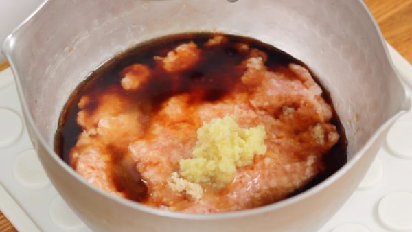 Let’s make the tori soboro. In a pot, combine the ground chicken thigh, sugar, soy sauce, sake and grated ginger root.