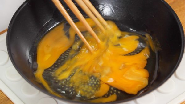 Let’s make the iri tamago. In a pan, combine the 2 eggs, mirin and a pinch of salt. Using 4 kitchen chopsticks, beat the egg thoroughly. If the mirin is not available, add a half tablespoon of sugar instead.