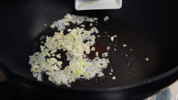 Add the chopped garlic clove and continue stirring. When the aroma grows stronger, increase the heat.