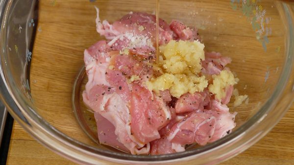 Coloque os pedaços em uma tigela. Adicione o molho de soja, sakê, sal, pimenta, gengibre e alho ralados e o óleo de gergelim.
