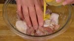 Let’s make the karaage. To the seasoned chicken, add the beaten egg a little at a time and rub it in thoroughly, almost squeezing it into the chicken. This will help soften the karaage and allow it to retain the savory juices inside.