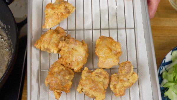 Quand l'extérieur est croustillant et que le poulet est bien doré, égouttez-les bien et placez-les un par un sur une grille. 