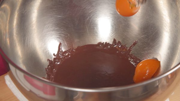 Now, remove the bowl of chocolate from the steam. First, add 2 egg yolks and mix with a spatula.