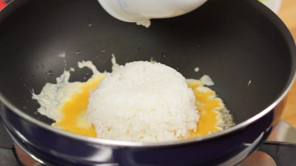 And quickly place the hot steamed rice into the pan.