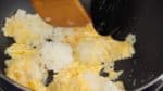 兩手各拿一把飯鏟，把米飯分散開，讓米粒均勻的包裹上雞蛋。繼續分散米粒，但是一定不要把米粒壓壞。