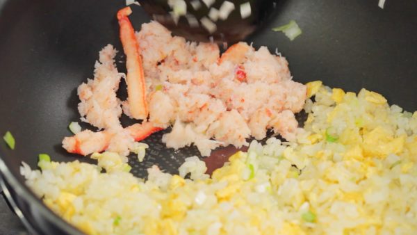 Ensuite, rassemblez le riz d'un côté et faites revenir la chair de crabe. Faites réduire le liquide du crabe et ensuite mélangez le crabe et le riz. 