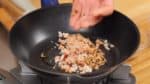 Erhitzt die Pfanne und träufelt etwas Sesamöl hinein. Bratet nun die Krabben und die Pilze auf kleiner Hitze in der Pfanne an. 