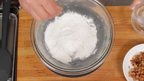 Let's make the mochi dough. Combine the grated daikon, regular rice flour, sticky rice flour and 2 pinches of salt.