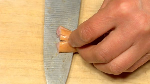 讓我們把香腸做成章魚的形狀。將香腸切成兩半。在香腸中途切開4片，形成8個觸角。注意不要割傷手。