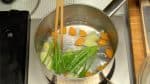 讓我們煮蔬菜。準備一鍋加鹽的水。放入土豆和胡蘿蔔，蓋上蓋子，然後打開燃燒器。當水沸騰時，先煮菠菜的莖部分。