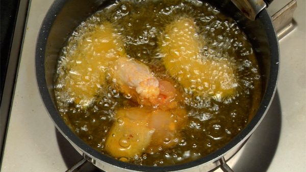 當南瓜開始發出嘶嘶聲時，將雞肉輕輕地倒入油中。將油中的南瓜和雞肉旋轉，讓它們均勻的炸製。