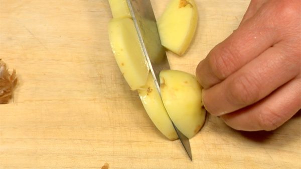 用小刀刮掉馬鈴薯的皮。將馬鈴薯切成切成半月形。