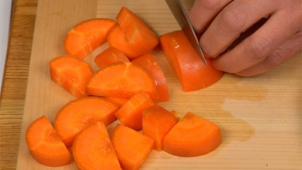 Meanwhile, let’s cut the vegetables. Cut the carrot in half lengthwise. Chop it into thick half moons.