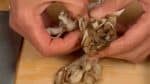 Avec vos mains, séparez les champignons maitake et ensuite coupez-les en petits morceaux.