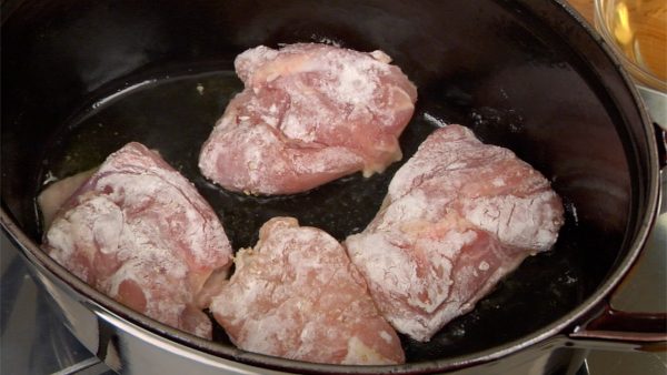 Add the olive oil to a heated pot. Place the chicken pieces into the pot with the skin side facing down.