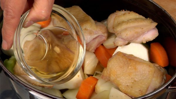 Place the reserved chicken into the pot and pour on the white wine. Continue to stir-fry, evaporating the alcohol completely.