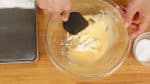 Agrega un tercio del queso mascarpone. Presiónalo con una espátula y combina la mezcla por completo.
