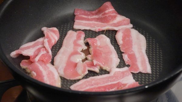 Let’s saute the ingredients. Heat a little sesame oil in a pan. Then, arrange the pork slices into it.