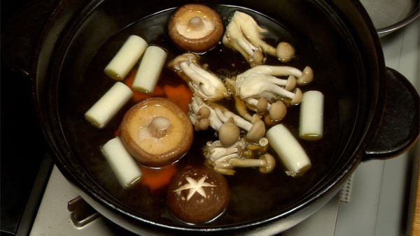 Add carrots, long green onions, shiitake and shimeji mushrooms.
