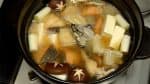 Faites mijoter environ 1 à 2 minutes et ajoutez le radis daikon râpé, le tofu mou, le saumon et le cabillaud du pacifique frits, les gâteaux de riz et les huîtres.