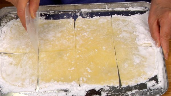 Let’s prepare 8 pieces of mochi for the mochi ice cream. Cut the sheet of mochi in half lengthwise and then cut it crosswise into 8 square pieces.