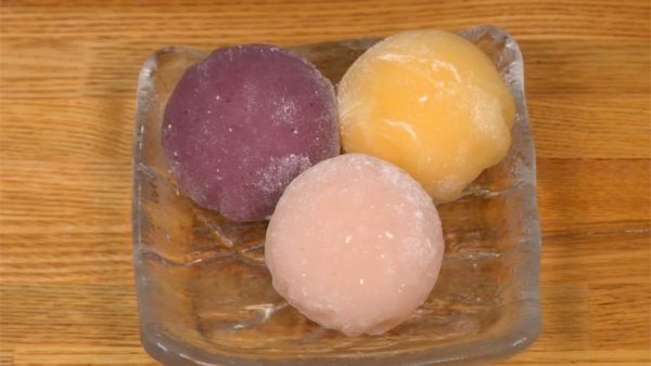 Now, the gelato is completely firmed up. Remove the clip and plastic wrap and place the mango mochi ice cream onto a plate. Put the blueberry and strawberry mochi ice cream next to it.
