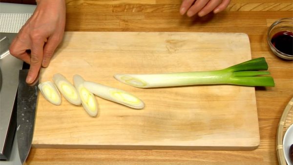 Let's prepare the ingredients for Nabeyaki Udon. Slice the long green onion diagonally. Chop the mitsuba parsley into 2~3cm (0.8"~1.2") pieces.
