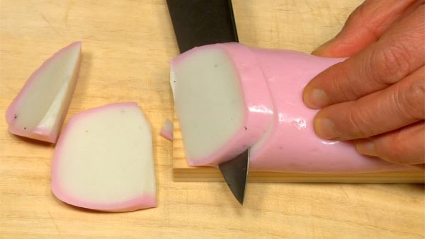 Unwrap the kamaboko fish cake. Separate the kamaboko from its base with the back of a knife. Slice the kamaboko diagonally.