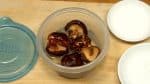 干し椎茸の含め煮を作ります。サッと水洗いした干し椎茸を容器に入れ水を加えます。